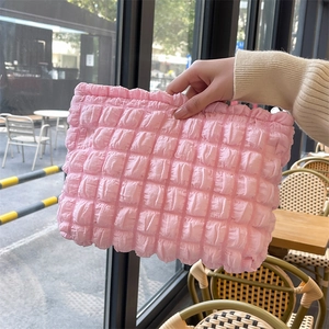 Detail showing the soft bubble texture of this light pink puffy storage cosmetics bag