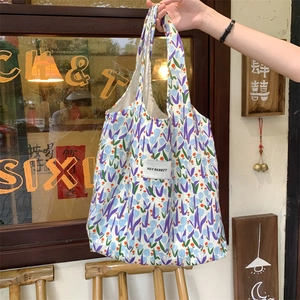 Détail d'un sac cabas en toile à fleurs avec tulipes violettes et étiquette de marque