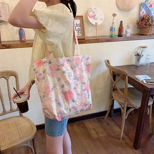 Détail d'un sac cabas en toile à fleurs avec motif floral et étiquette de logo