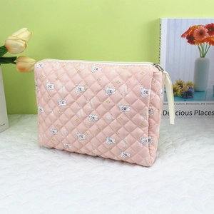 Detail of pink quilted makeup bag with white puppy prints and a convenient zipper puller