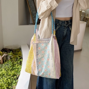 Dettaglio della borsa tote patchwork floreale con manici in corda blu e etichetta bianca