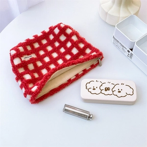 Close-up of red and white waffle texture plush cosmetic bag with zipper detail