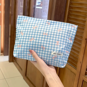 Dettaglio della borsa da toilette a quadretti blu con fiocchi rosa ed etichetta in tessuto