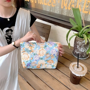Floral makeup bag in light blue canvas with vintage patterns and branded woven label