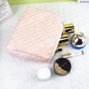 Detail of pink quilted makeup bag with cute rabbit prints and smooth zipper closure