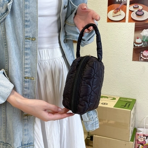 Détail du tissu noir matelassé à motif de cœur et de la fermeture éclair de ce sac