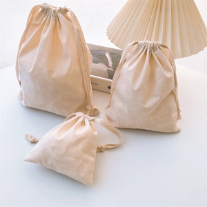 Three-piece set of cream canvas drawstring storage bags in various sizes for home organizing