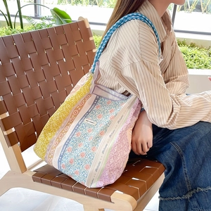 Dettaglio della borsa tote floreale con manico in corda intrecciata e motivi vintage