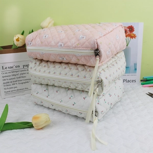 Three-piece quilted makeup bag set featuring bear, floral, and cherry prints with silk ribbons