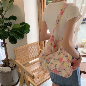 Lifestyle shot of floral shoulder bag showing large capacity and comfortable wide strap