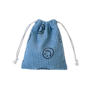 Light blue corduroy drawstring pouch with black smiley face prints on white background