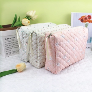 Quilted floral makeup bag detail with metal zipper and soft printed cotton texture