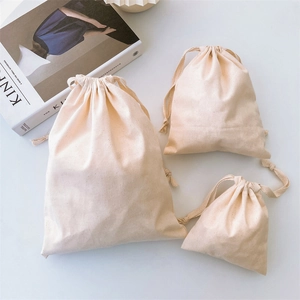 Three sizes of eco-friendly cotton drawstring bags shown with a minimalist magazine