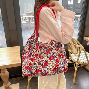 Dettaglio della borsa tote floreale con motivi colorati e manico in corda rossa