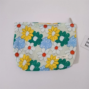 Detail of floral makeup bag with daisy patterns and silver metal zipper closure