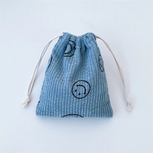 Blue corduroy drawstring bag with black smiley faces and white cotton ropes
