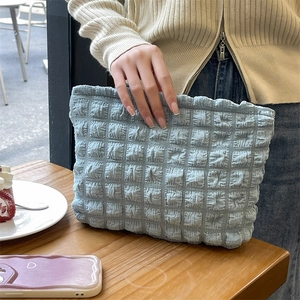 Detail shot of light blue bubble texture fabric on a stylish large capacity cosmetic bag