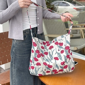 Detailed texture of white floral canvas tote bag with red poppy patterns in soft cotton