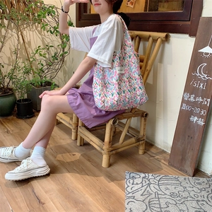 Détail d'un sac cabas en toile avec motifs de tulipes florales et étiquette tissée