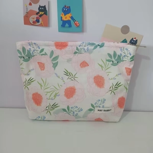 Close-up of the floral makeup bag showing the metal zipper and floral fabric details