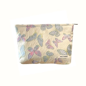 Embossed floral jacquard makeup bag with butterfly embroidery and top zipper closure