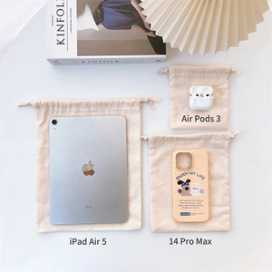 Three sizes of beige cotton drawstring bags shown with an iPad and phone for scale