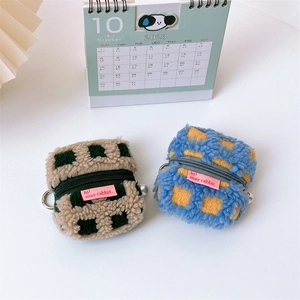 Detail of plush checkerboard earphone cases with metal rings and pearl pendants
