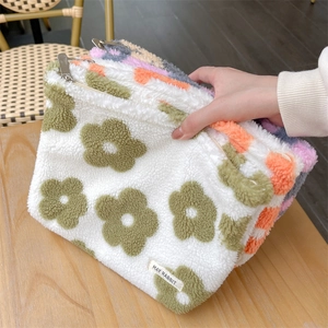 Detail of plush floral makeup bag with lamb wool texture and silver metal zipper