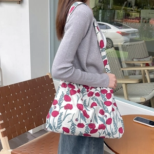 Detail showing red poppy floral print on white cotton canvas tote with wide shoulder strap