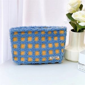 Detail of blue and orange waffle checkered fleece makeup bag with May Rabbit label