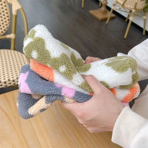Close-up of fluffy floral plush makeup bags showing soft lamb wool texture and brand label