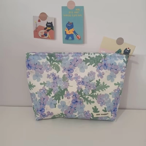 Detail of floral makeup bag with blue and purple flowers and May Rabbit brand label
