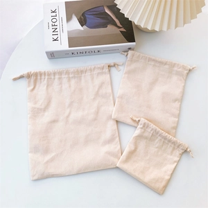 Three-piece set of cream canvas drawstring storage bags in various sizes for home organizing