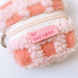 Detail of pink checkerboard waffle velvet earphone pouch with metal clip and zipper