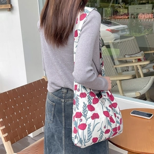 Detailed back view of a floral canvas tote bag with pink flowers on a wide shoulder strap