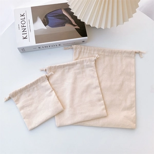 Three-piece set of natural cotton drawstring storage bags in various sizes for organization