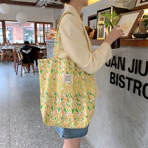 Détail d'un sac cabas en toile à fleurs avec motifs tulipes et écusson décoratif