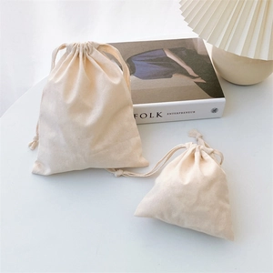 Close-up of textured cotton drawstring bags showing fabric grain on white background