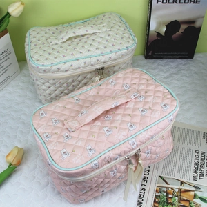 Detail view of quilted floral and bunny makeup bags with top handle and double zippers