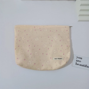 Close-up of May Rabbit beige cosmetic bag with floral rabbit pattern and zipper