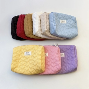 Quilted heart pattern makeup bags in multiple colors shown in a flat lay arrangement