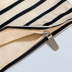 Detail of the high-quality striped fabric with smooth hidden zipper and silver metal puller