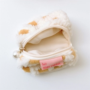 Detailed view of plush checkered storage bag with pearl zipper and soft texture lining