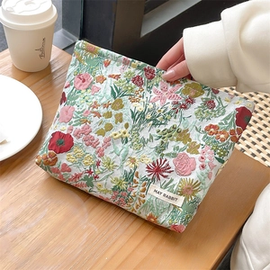 Macro detail of floral jacquard embroidery texture and brand label on makeup bag