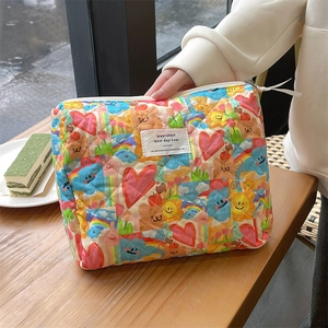 Detailed shot of quilted floral cosmetic bag with cartoon bear and rainbow patterns