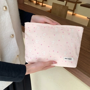 Close-up of cute floral makeup bag with pink strawberry and rabbit patterns