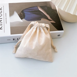 Detail of off-white cotton drawstring bag texture on a magazine in bright soft lighting