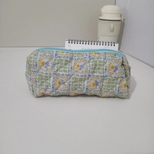 Detailed view of the quilted floral fabric and blue zipper of the stationery pouch