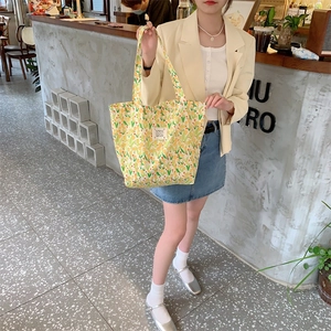 Détail du cabas en toile florale avec motifs de tulipes jaunes et écusson en tissu tissé