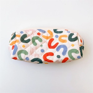 Macro view of quilted fabric storage bag with colorful geometric patterns and white zipper